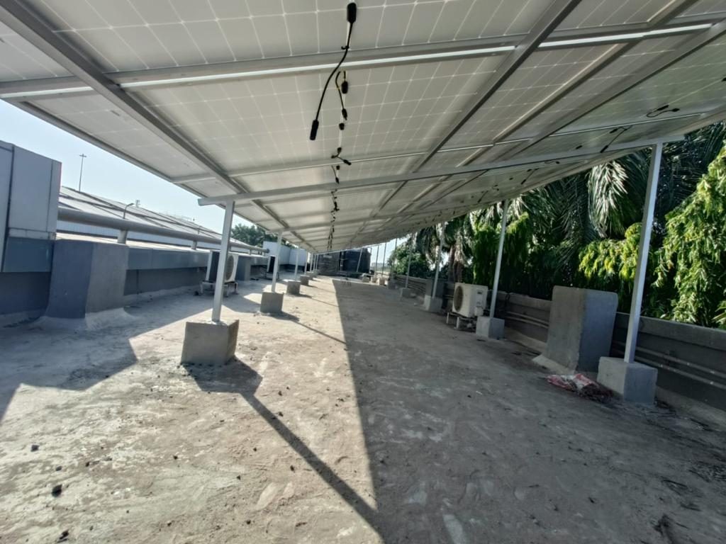 Elevated solar carport structure installed over a factory rooftop